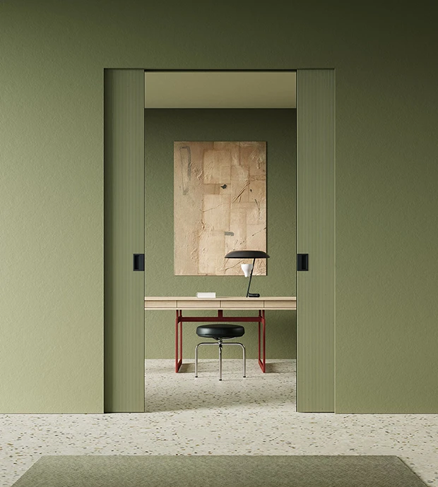 Porta interna scorrevole filo muro verde salvia in ambiente moderno